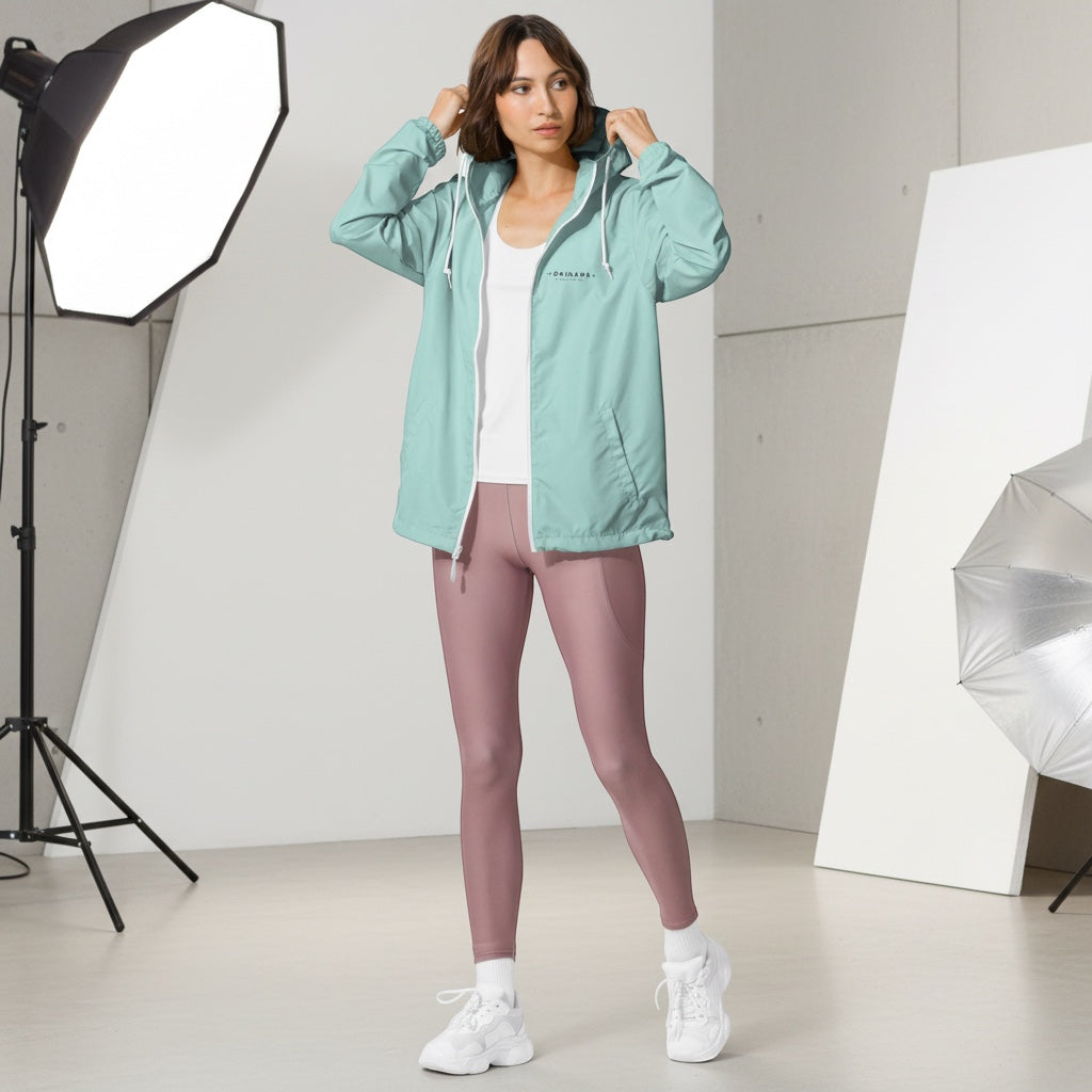 Model wearing a YUTASHA Toshie light green water-resistant windbreaker with a hood and white zipper in a studio.