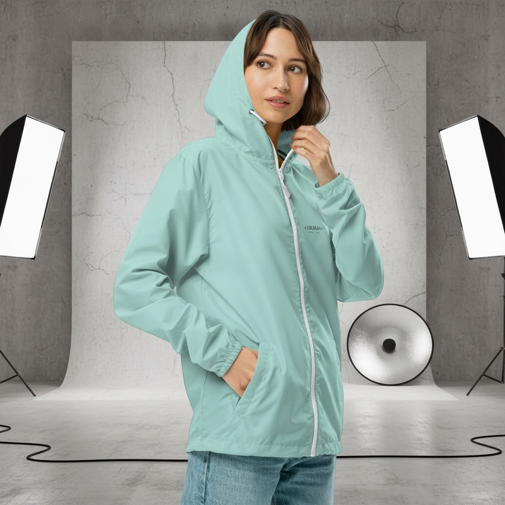 YUTASHA Toshie windbreaker in light mint green with a hood, white zipper, and elastic cuffs worn by a woman